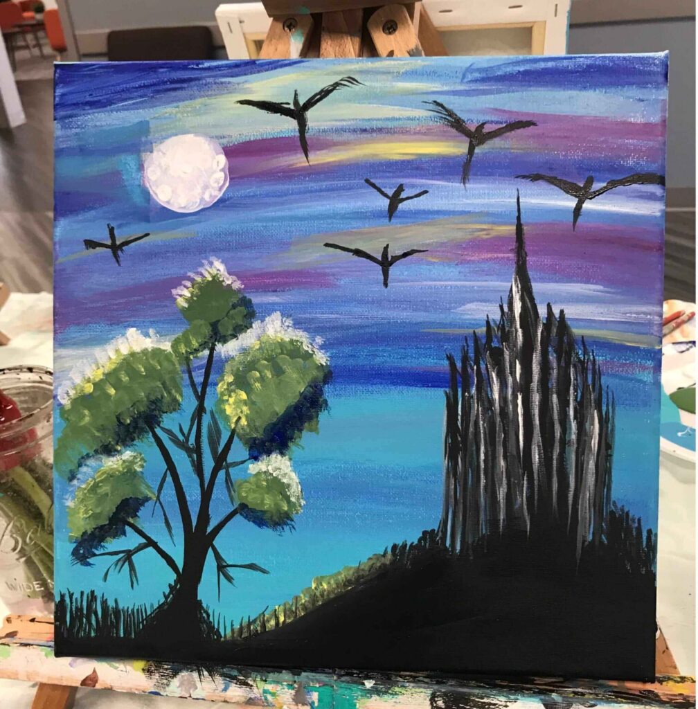 A colorful painting shows a bright moon, birds flying in a twilight sky, a tree with green leaves, and a dark, spiky castle on a hill, with shades of blue, purple, and yellow in the background.