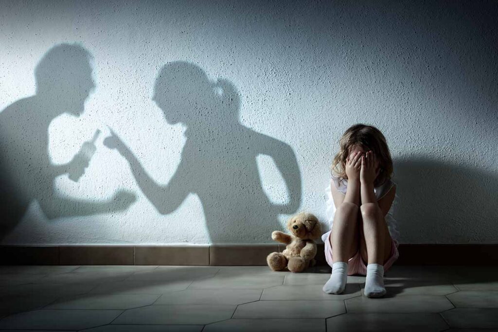 how substance abuse affects the family, shadow of parents fighting above child sitting against wall with face covered